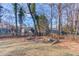 Well-maintained backyard with decorative flower bed and mature trees, a peaceful oasis at 5883 Riverside Walk Dr, Sugar Hill, GA 30518