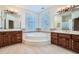 Bright bathroom featuring a large soaking tub between two vanities with decorative tile accents at 1725 Patriots Nw Way, Kennesaw, GA 30152