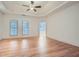 Spacious primary bedroom featuring hardwood floors, tray ceiling, and connecting en-suite bathroom at 1725 Patriots Nw Way, Kennesaw, GA 30152