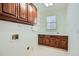 Laundry room with upper cabinets, folding counter, a sink, and a window for natural light at 1725 Patriots Nw Way, Kennesaw, GA 30152