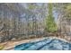 An in-ground pool with a pool deck is surrounded by lush trees and landscaping, offering privacy at 1725 Patriots Nw Way, Kennesaw, GA 30152