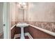 Elegant powder room featuring a pedestal sink, decorative wallpaper, and trim at 1725 Patriots Nw Way, Kennesaw, GA 30152