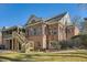 A brick house with a wooden staircase leading to a screened porch and a well-maintained lawn at 1725 Patriots Nw Way, Kennesaw, GA 30152