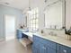 Bathroom with blue cabinets, a white marble countertop, and a large framed mirror above sink at 2629 Ashford Ne Rd, Brookhaven, GA 30319