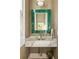 Powder room featuring a green framed mirror and marble countertop at 2629 Ashford Ne Rd, Brookhaven, GA 30319