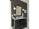 Bathroom boasting a black vanity with marble countertop, brass fixtures, and gray walls at 2629 Ashford Ne Rd, Brookhaven, GA 30319