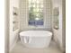 Bright bathroom features a large soaking tub, a large window, and built in shelves on either side of the tub at 2629 Ashford Ne Rd, Brookhaven, GA 30319