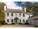 Grand two-story home with a brick driveway, lush landscaping, and attached garage at 2629 Ashford Ne Rd, Brookhaven, GA 30319