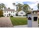 Two-story white home with brick driveway, lawn, and white brick fence with home address at 2629 Ashford Ne Rd, Brookhaven, GA 30319