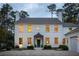 Elegant two-story white home at dusk featuring a dark front door, brick driveway, and manicured landscaping at 2629 Ashford Ne Rd, Brookhaven, GA 30319