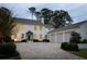 Elegant two-story white home at dusk featuring a brick driveway, attached garage, and manicured landscaping at 2629 Ashford Ne Rd, Brookhaven, GA 30319