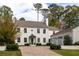 Elegant white home with attached garage, brick driveway, manicured lawn, and tasteful shrubbery at 2629 Ashford Ne Rd, Brookhaven, GA 30319