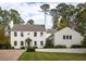 Charming two-story white home featuring a brick driveway, lush green lawn, and beautiful landscaping at 2629 Ashford Ne Rd, Brookhaven, GA 30319