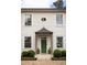 Close up of the front door featuring a dark green door, black awning, and manicured shrubs at 2629 Ashford Ne Rd, Brookhaven, GA 30319