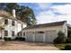 Spacious three-car garage attached to a white home, featuring a brick driveway and manicured shrubs at 2629 Ashford Ne Rd, Brookhaven, GA 30319