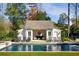 Inviting backyard pool with a charming pool house and ample lounge seating at 2629 Ashford Ne Rd, Brookhaven, GA 30319