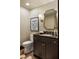 Powder room with gold hardware, a decorative mirror and sconce, and a patterned countertop at 2629 Ashford Ne Rd, Brookhaven, GA 30319