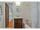 Well-lit bathroom featuring a classic vanity with wood cabinet, tile surround, and a shower with a curtain at 2941 Pine Valley Cir, East Point, GA 30344