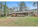 Spacious backyard showcasing the home's exterior, deck, and screened porch with mature trees at 2941 Pine Valley Cir, East Point, GA 30344