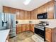 Well-equipped kitchen with stainless steel appliances, wood cabinets, and stone tile floors at 530 Firethorn Ct, Villa Rica, GA 30180