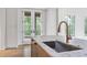 Close up on kitchen featuring marble countertop island, stainless steel sink and fixtures, and white cabinetry at 96 Sheridan Dr, Atlanta, GA 30305