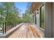 Expansive porch with natural wood floors, sleek black railings, and scenic views of the surrounding trees at 96 Sheridan Dr, Atlanta, GA 30305