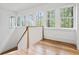 Bright stair landing with hardwood floors, white wainscoting, and multiple windows at 96 Sheridan Dr, Atlanta, GA 30305