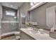 Modern bathroom showcasing a glass-enclosed shower, stylish vanity with quartz countertop, and large framed mirror at 3220 Celebration Blvd, Suwanee, GA 30024