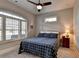 Cozy bedroom featuring a ceiling fan, a large window with shutters, and a comfortable-looking bed at 3220 Celebration Blvd, Suwanee, GA 30024