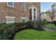 Brick townhome showcasing manicured lawn, dark mulch bed, and walkway to the covered front entryway at 2111 Lilly Nw Way, Atlanta, GA 30318