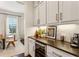 Wet bar includes a wine fridge, white cabinets, granite countertops, and modern backsplash at 2111 Lilly Nw Way, Atlanta, GA 30318