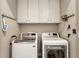 Clean and organized laundry room with modern washer and dryer units and storage cabinets at 2111 Lilly Nw Way, Atlanta, GA 30318