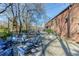 Brick building featuring outdoor seating area with blue chairs, overhead string lights, and lush foliage at 2111 Lilly Nw Way, Atlanta, GA 30318