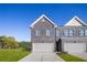 Modern townhome with a gray brick facade, two-car garage, and well-maintained lawn at 225 Epping St # 92, Stockbridge, GA 30281