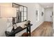 Hallway featuring wood floors, a decorative mirror, a sleek black table with decor at 225 Epping St # 92, Stockbridge, GA 30281