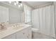 Well-lit bathroom with a single sink vanity, toilet, and shower with a white curtain at 305 Brassy Ct, Alpharetta, GA 30022