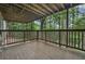 Exterior view of the covered deck showcasing the wood flooring and surrounding wooded landscape at 305 Brassy Ct, Alpharetta, GA 30022