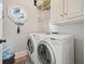 Well-equipped laundry room featuring modern washer and dryer, storage cabinets and an octagon mirror at 305 Brassy Ct, Alpharetta, GA 30022