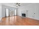 Bright living room with fireplace, hardwood floors, large windows, and a ceiling fan at 305 Brassy Ct, Alpharetta, GA 30022