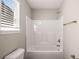 Bathroom featuring a shower-tub combination, window, and neutral color palette at 325 Nutwood Trce, Locust Grove, GA 30248