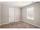 Bedroom with a window providing natural light and neutral carpet at 325 Nutwood Trce, Locust Grove, GA 30248