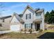 Charming two-story home with light gray siding, black shutters, attached garage and well-kept lawn at 325 Nutwood Trce, Locust Grove, GA 30248