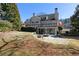 Expansive backyard featuring a stone patio with fire pit, blending outdoor living with natural surroundings at 3894 Stone Lake Nw Dr, Kennesaw, GA 30152