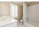 Cozy bathroom with a tub/shower combo, white tiled walls, and a white vanity next to a shuttered window at 3894 Stone Lake Nw Dr, Kennesaw, GA 30152