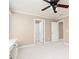 Spacious bedroom with neutral paint, plush carpet, a ceiling fan, and multiple access doors at 3894 Stone Lake Nw Dr, Kennesaw, GA 30152