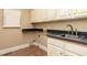 Functional laundry room with upper cabinets, sink, and tile flooring at 3894 Stone Lake Nw Dr, Kennesaw, GA 30152