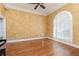 Bright living room with hardwood floors, textured walls, ceiling fan, and arch window with plantation shutters at 3894 Stone Lake Nw Dr, Kennesaw, GA 30152