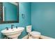 Stylish powder room with a pedestal sink, decorative mirror, and blue walls at 3894 Stone Lake Nw Dr, Kennesaw, GA 30152