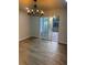 Dining area featuring modern chandelier, wood-look floors and sliding door to backyard deck at 1753 Lee St, Decatur, GA 30035