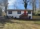 Charming single story home with white siding, black shutters, and a bright red front door at 1753 Lee St, Decatur, GA 30035